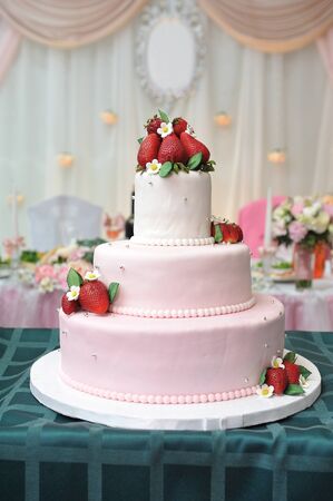 Beautiful wedding cake decorated with mastic and strawberries.の写真素材
