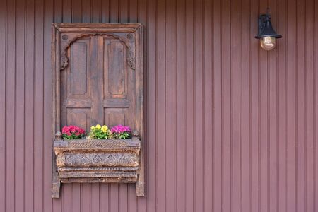Antique wooden wall with wooden shutters and a hanging lamp in a European village in Germanyの写真素材