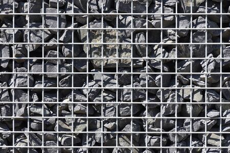 Texture of gabion fence, made of durable mesh and large stones. European fence of mesh and stonesの写真素材