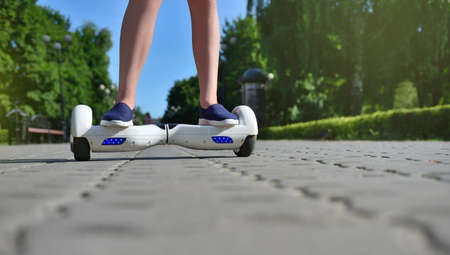 Girl child uses a hoverboard for riding in the park