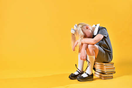 Young schoolgirl is tired and wants to sleep