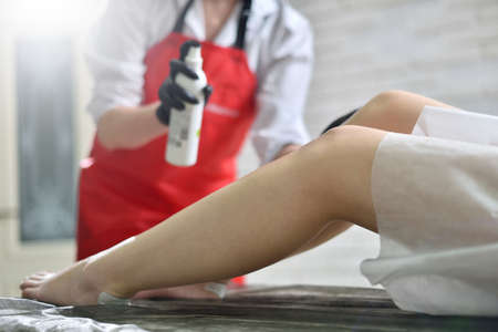 Female legs and lotion, depilation process. The concept of depilation, beauty and skin care.の写真素材