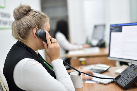 A woman works in the call center and talks on the phone with customers