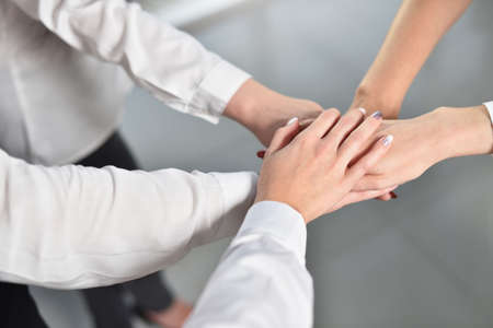 The united hands of female employees for concentration and teamwork success. Together, anything is...