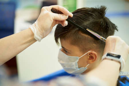 Teenager wearing face mask at barber shop during pandemicの写真素材
