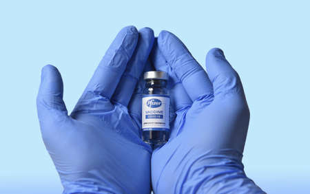 STARIY OSKOL, RUSSIA - NOVEMBER 23, 2020: Doctor with hope of salvation holds new vaccine for coronavirus made by Pfizerのeditorial素材
