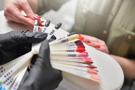 Woman chooses color of nail polish at nail salon