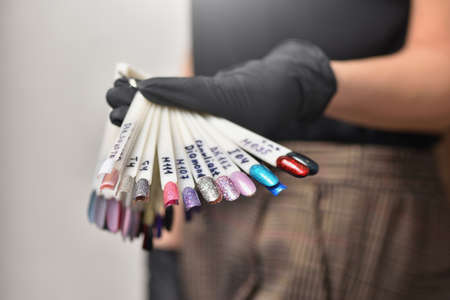 Manicurist demonstrating nail polish color optionsの写真素材