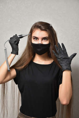 Young woman manicurist posing with electric nail file, nail care conceptの写真素材