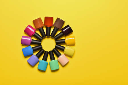 Set of colorful nail polishes on yellow backgroundの写真素材
