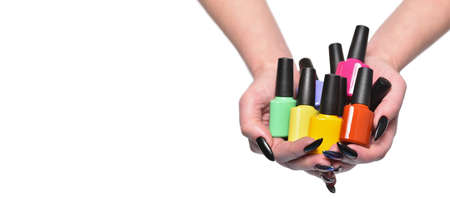 Female hands holds nail polishes bottles, isolated on white