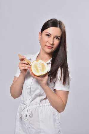 Depilation master holding grapefruit in hands, concept of female intimate depilationの写真素材