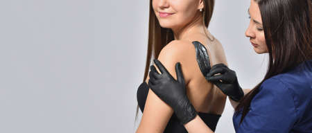 Beautician doing waxing depilation on back, body care and femininity conceptの写真素材