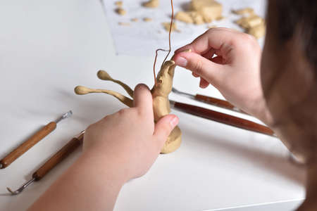 The child sculpts a figure from plasticine, childrens hobbies and creativity