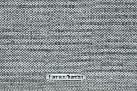 STARIY OSKOL, RUSSIA - MAY 19, 2021: Harman Kardon logo on gray fabric of audio equipmentsのeditorial素材