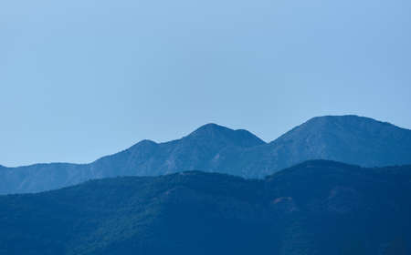 Blue mountain peaks against the blue sky in the morningの写真素材