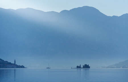 Small island against the backdrop of large mountains, Morning landscape in the adriatic sea in Montenegroの写真素材