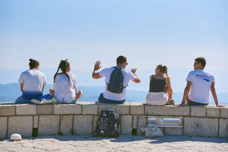 CETINJE, MONTENEGRO - JULY 20, 2021: A group of tourists listens attentively to the story of their...