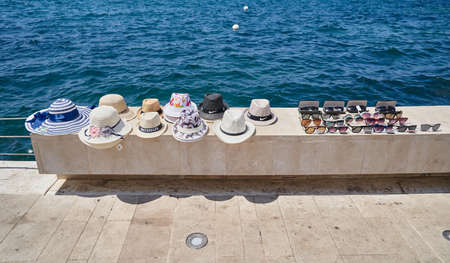 TIVAT, MONTENEGRO - JULY 15, 2021: Sale of hats and glasses by the sea on the promenade