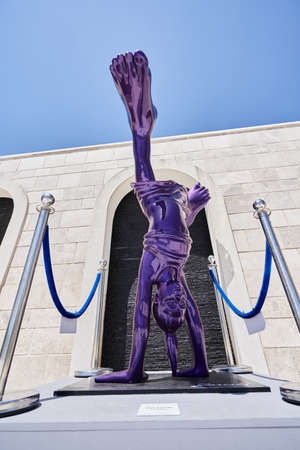 TIVAT, MONTENEGRO - JULY 15, 2021: Modern violet sculpture of a girl upside down on a city streetのeditorial素材