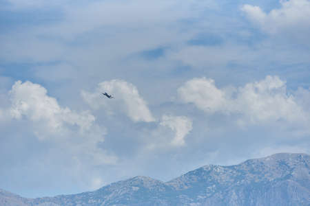Passenger plane against the background of the sky with clouds and mountains