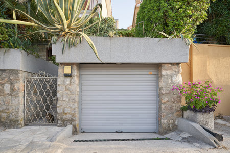 Garage with gray door and greenery on the roofの写真素材