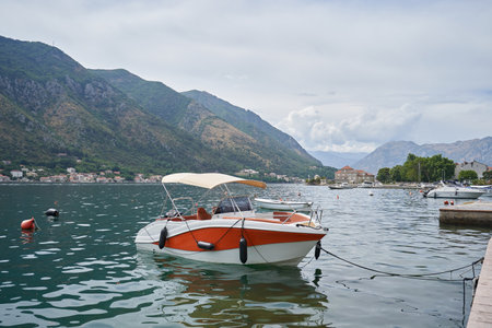 Small yacht with tent roof is moored in Kotor bayの写真素材