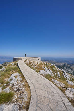 Tourist at the view point of the mountain raised his hand up in success. Lovcen, Montenegroの写真素材