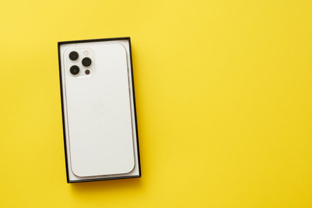 STARIY OSKOL, RUSSIA - JULY 5, 2021: New smartphone from apple iPhone in box on yellow backgroundのeditorial素材