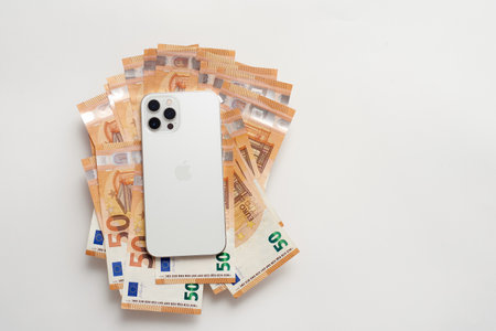 STARIY OSKOL, RUSSIA - JULY 5, 2021: New white iPhone on Euro billsのeditorial素材