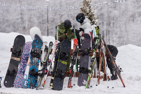 ARKHYZ, RUSSIA - FEBRUARY 9, 2022: Snowboards and skis stand at a special rack in a ski resortのeditorial素材