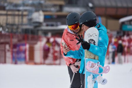 ARKHYZ, RUSSIA - FEBRUARY 8, 2022: Two women skier looking at smartphoneのeditorial素材
