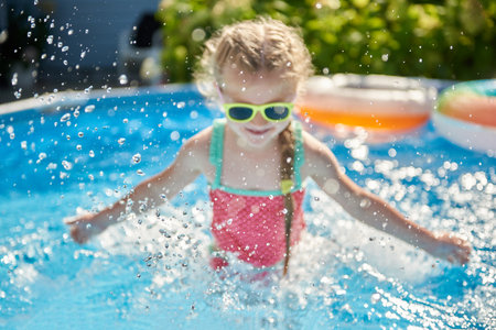 Abstract image with splashes of water as a child has fun swimming in a poolの写真素材