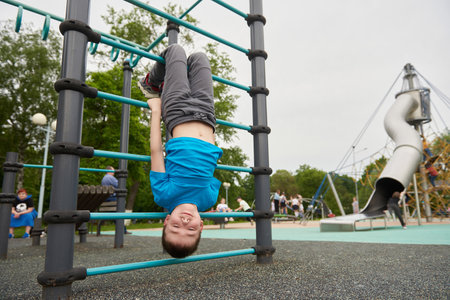 A child is hanging upside down on a childrens playground