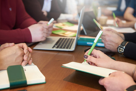 Hands of people in a business meeting at a desk in the officeの写真素材