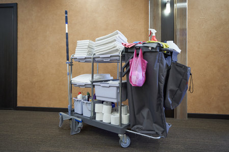 A hotel maid cart with cleaning supplies, clean towels and bedclothesの写真素材