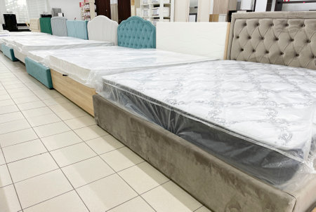 Luxury beds with soft headboards for sale at furniture storeの写真素材
