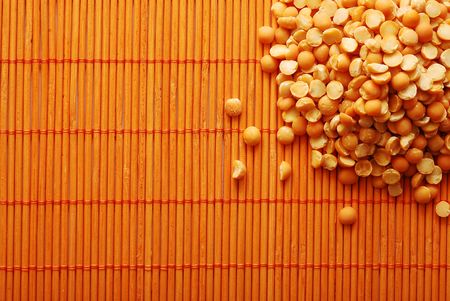 orange lentil over bamboo matの写真素材