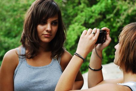 girls having fun with pocket cameraの写真素材