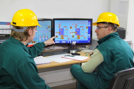 Industrial workers in control room Industrial workers in control room