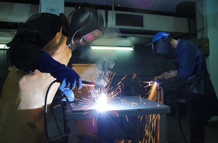 Steel Workers welding, grinding, cutting in metal industryの写真素材