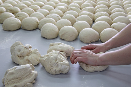 Female baker kneading dough in a bakeryのeditorial素材