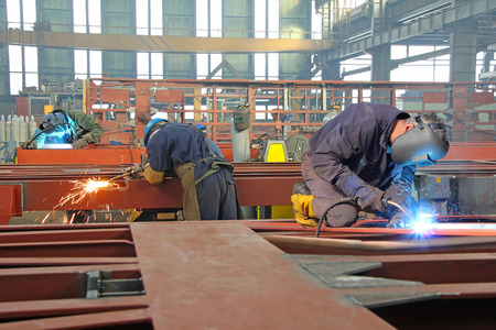 Steel workers welding, grinding, cutting in metal industryの写真素材
