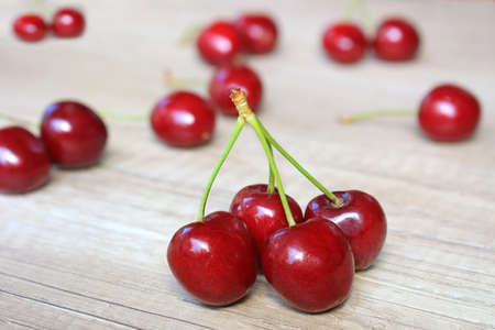 Fresh cherries on wooden background, close up of juicy ripe fruitの写真素材