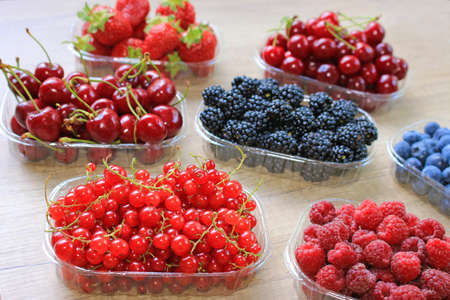 Fresh berries on wooden background, strawberry, blueberry, raspberry, blackberry, cherry and red...