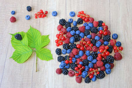 Fresh berries on wooden background, strawberry, blueberry, raspberry, blackberry and red currantの写真素材