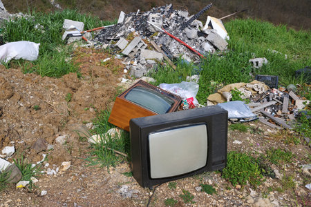 Old retro television set at a junkyard. Broken TV with garbage dump, environmental pollutionの写真素材