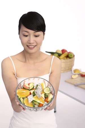 Woman holding a bowl of fruit saladの写真素材