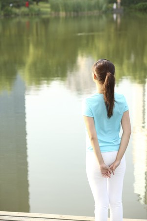Woman standing by the lakeの写真素材