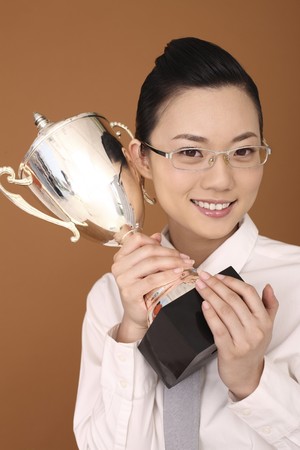 Businesswoman holding trophyの写真素材